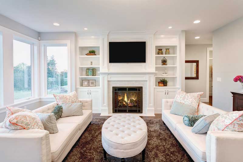 Living room with fire place, bay windows and mounted tv.